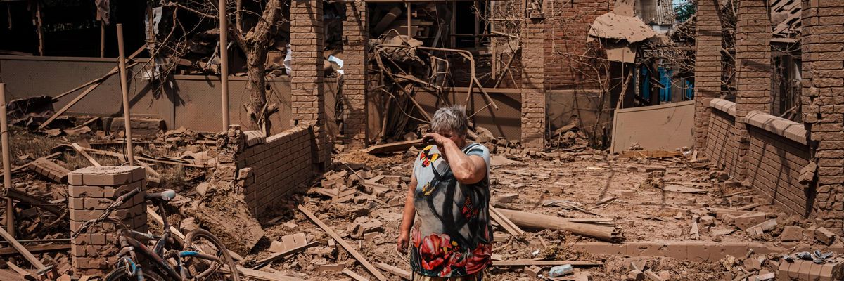 A woman cries as she gathers her belongings after a bombardment hit their homes along a road heading into Lysychansk, Ukraine, Monday June 13, 2022