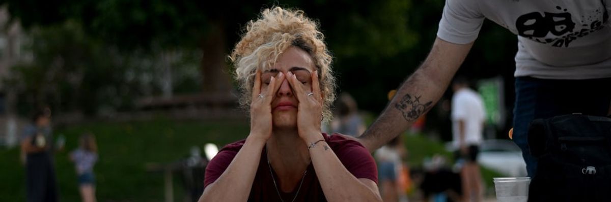 A woman cries while lighting a memorial candle outside Habima on October 20, 2023 in Tel Aviv, Israel.