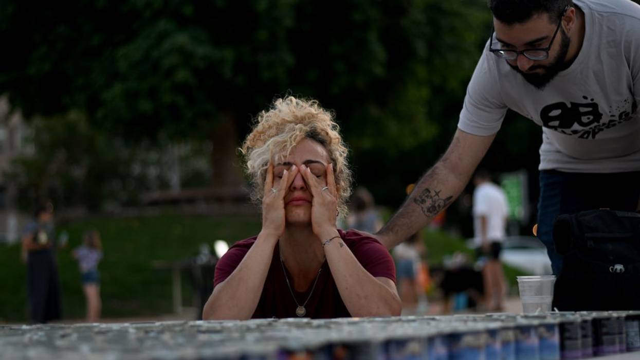 A woman cries while lighting a memorial candle outside Habima on October 20, 2023 in Tel Aviv, Israel.