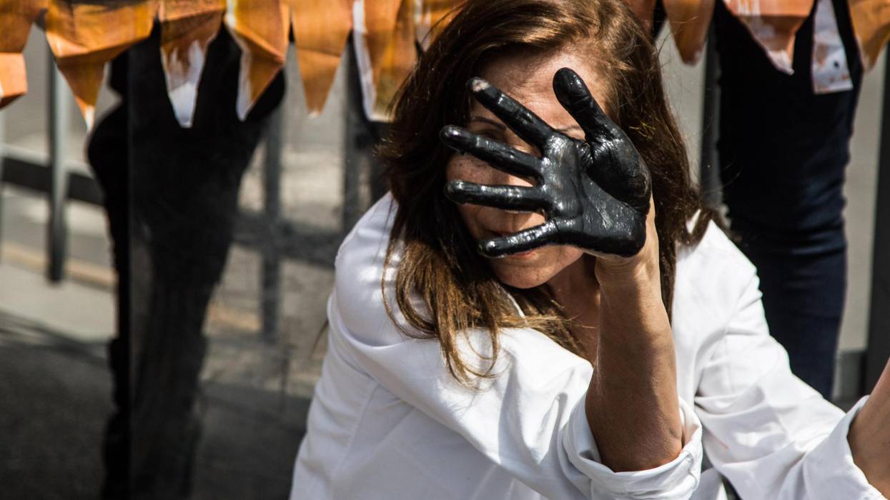 A woman displays oil on her hands at a protest