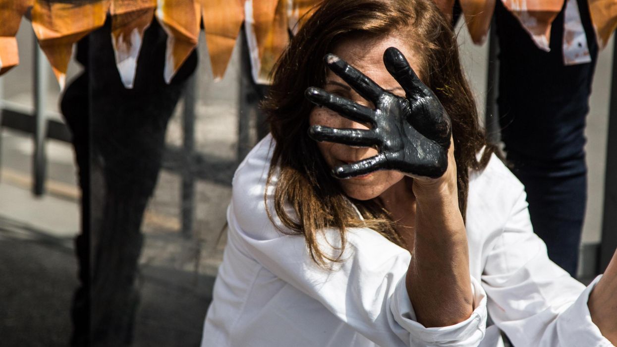 A woman displays oil on her hands at a protest