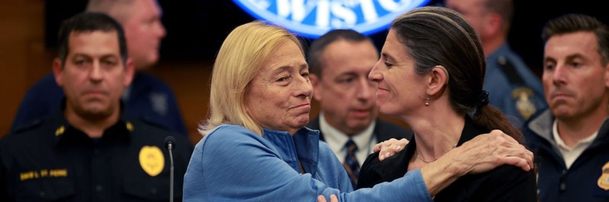 A woman embraces Gov. Janet Mills at a press conference.
