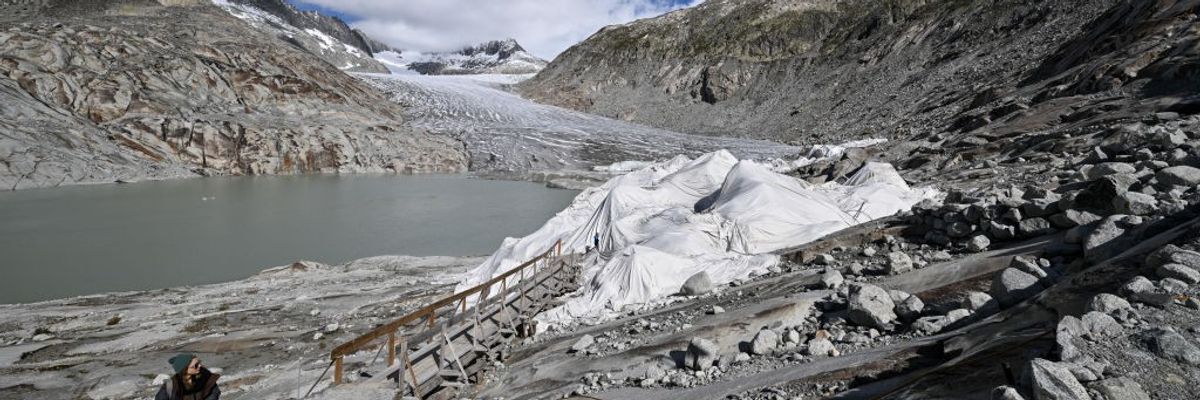 A woman exits an ice cave in the Swiss Alps
