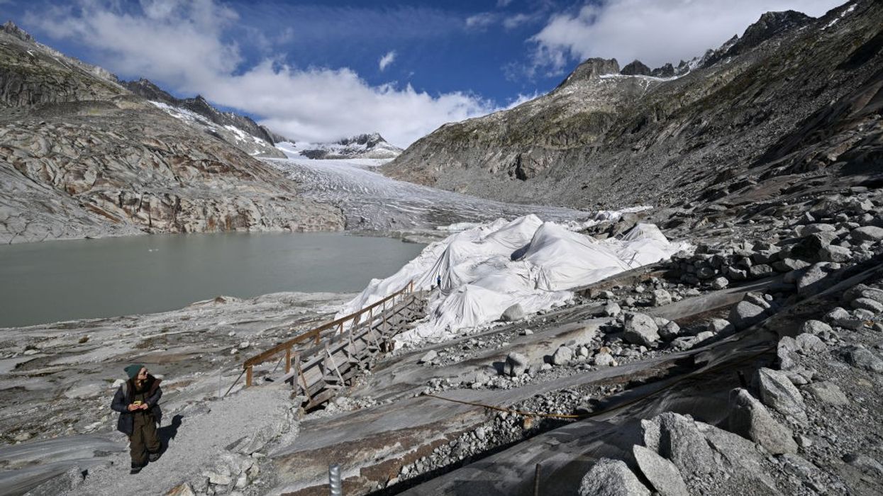 A woman exits an ice cave in the Swiss Alps