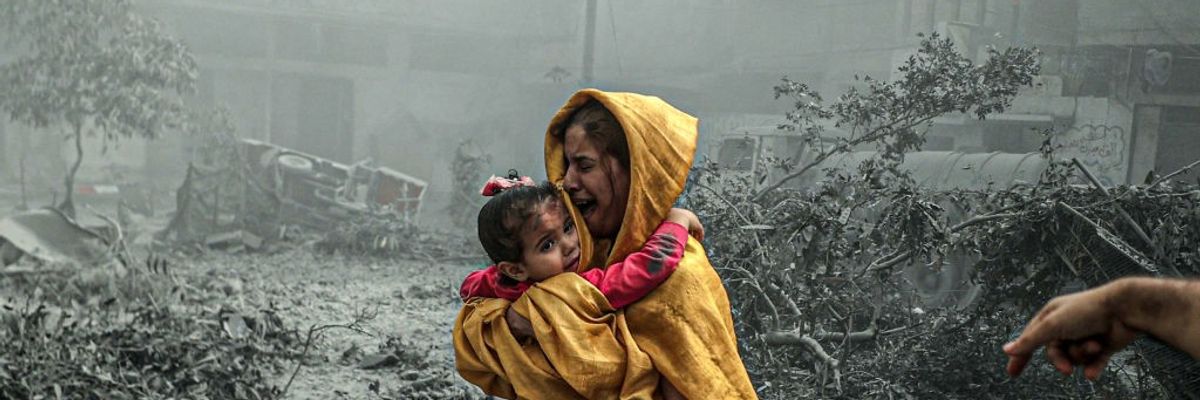 A woman holding a girl reacts after Israeli airstrikes hit the Ridwan neighborhood of Gaza City