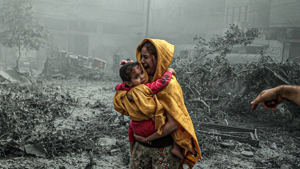 A woman holding a girl reacts after Israeli airstrikes hit the Ridwan neighborhood of Gaza City