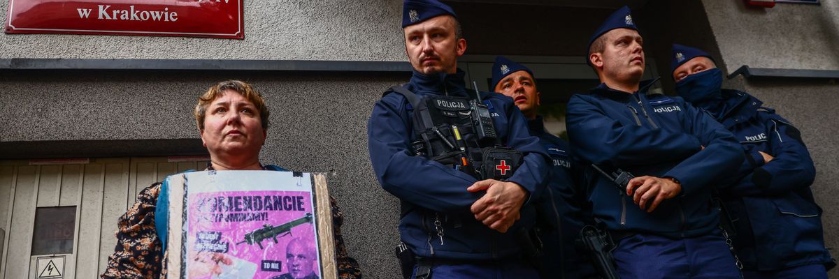 A woman holds a banner outside a police station in Poland