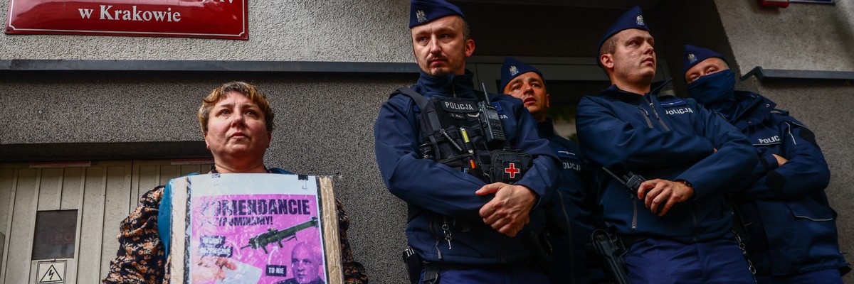A woman holds a banner outside a police station in Poland