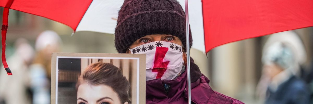 A woman holds a picture of a woman who died due to Poland's abortion ban