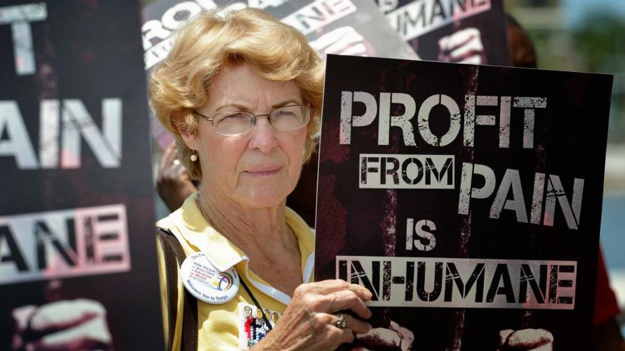 A woman holds a sign at a 2012 rally against private prisons