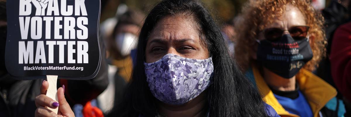 A woman holds a sign reading, "Black voters matter"