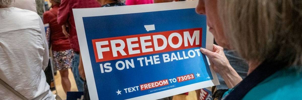 A woman holds a sign supporting an abortion rights ballot measure