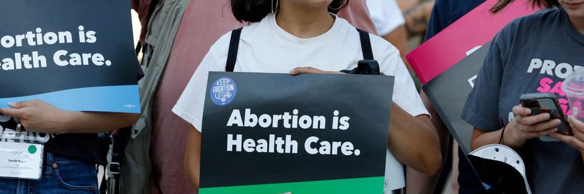 A woman holds an "Abortion is Health Care" sign