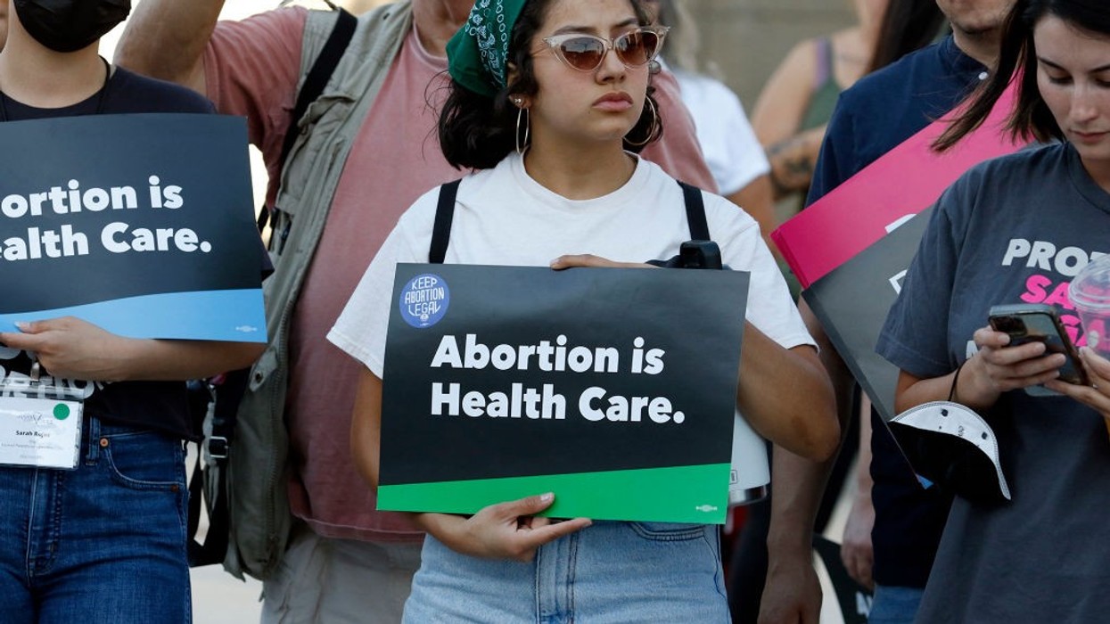 A woman holds an "Abortion is Health Care" sign