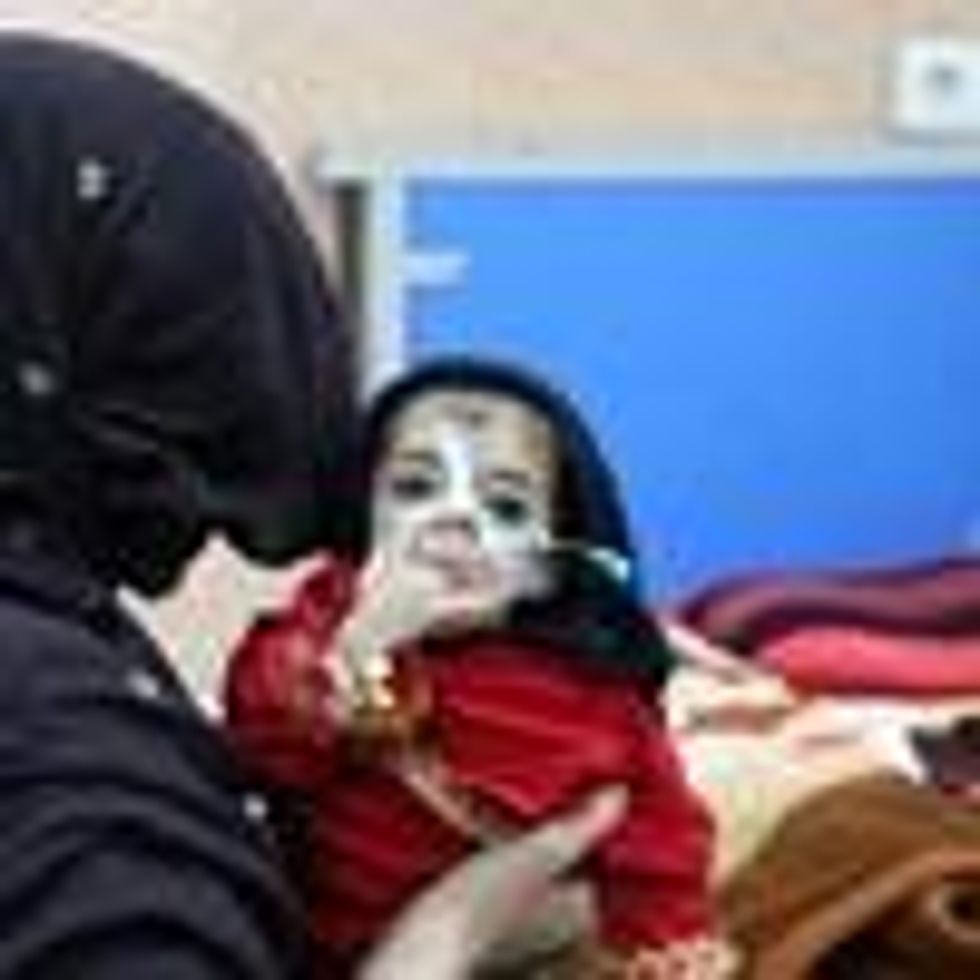A woman holds an Afghan baby suffering from hunger