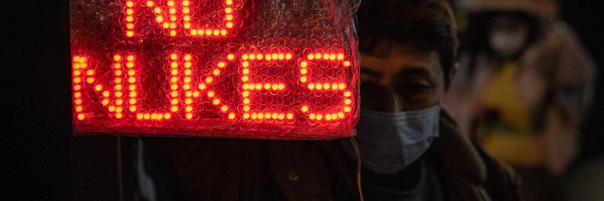 A woman holds an LED board saying No Nukes during a vigil near the Russian embassy following the Russian invasion of Ukraine, on March 4, 2022 in Tokyo