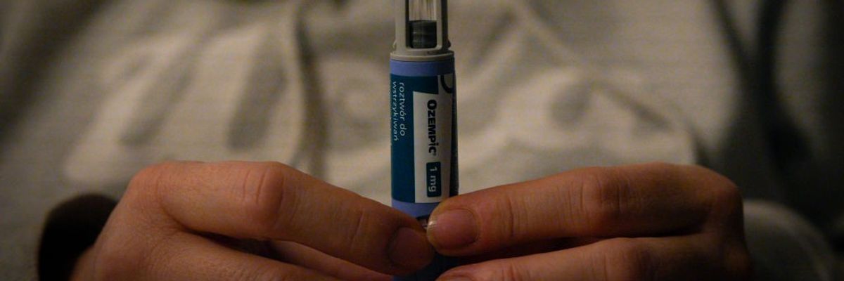 A woman holds an Ozempic pen