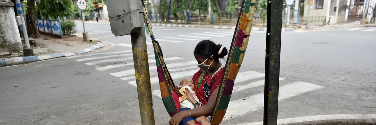 A woman holds her child on her lap in Kolkata, India on May 7, 2020.