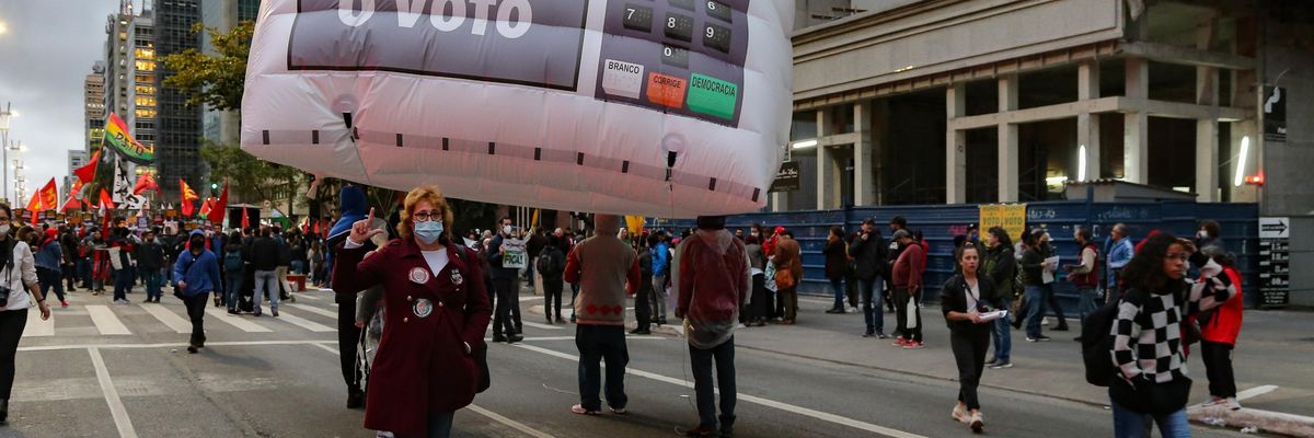 A woman holds sign reading "Respect the Vote in Brazil