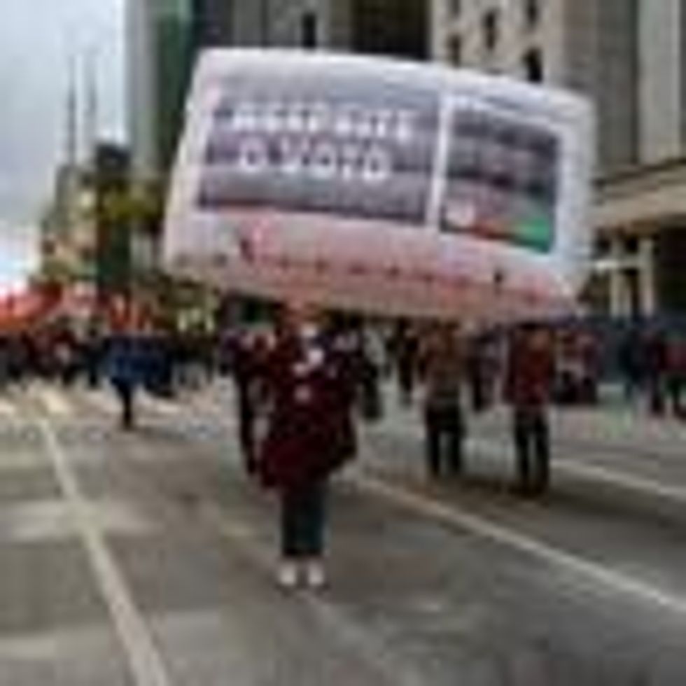 A woman holds sign reading