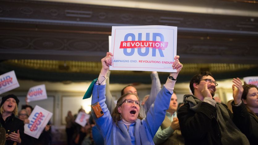 A woman holds up an Our Revolution sign.