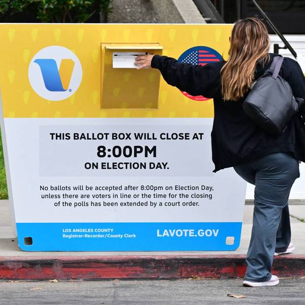 A woman inserts her ballot in a drop box