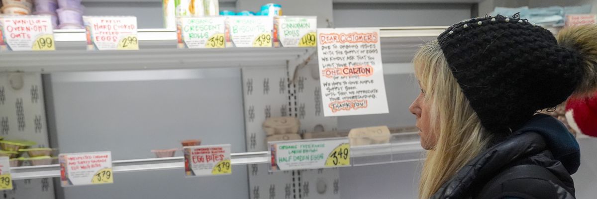A woman looks at an empty shelf at Trader Joe's market