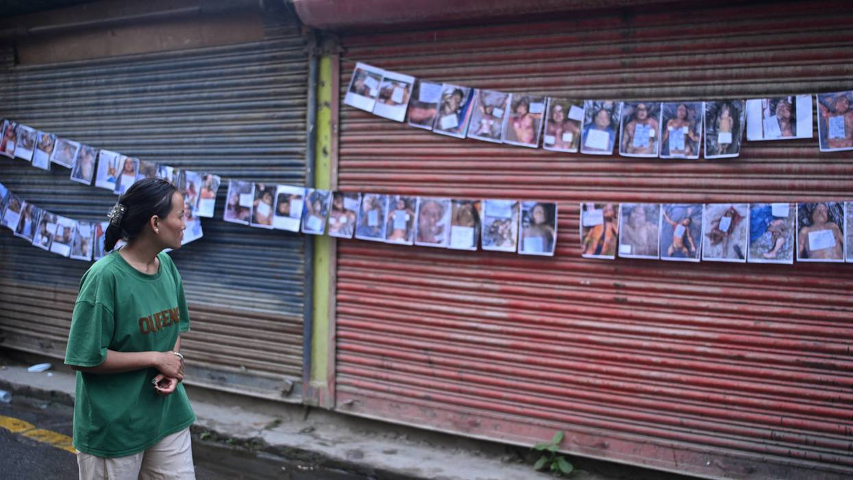 A woman looks at photographs of the missing and dead following flash floods in Nepal