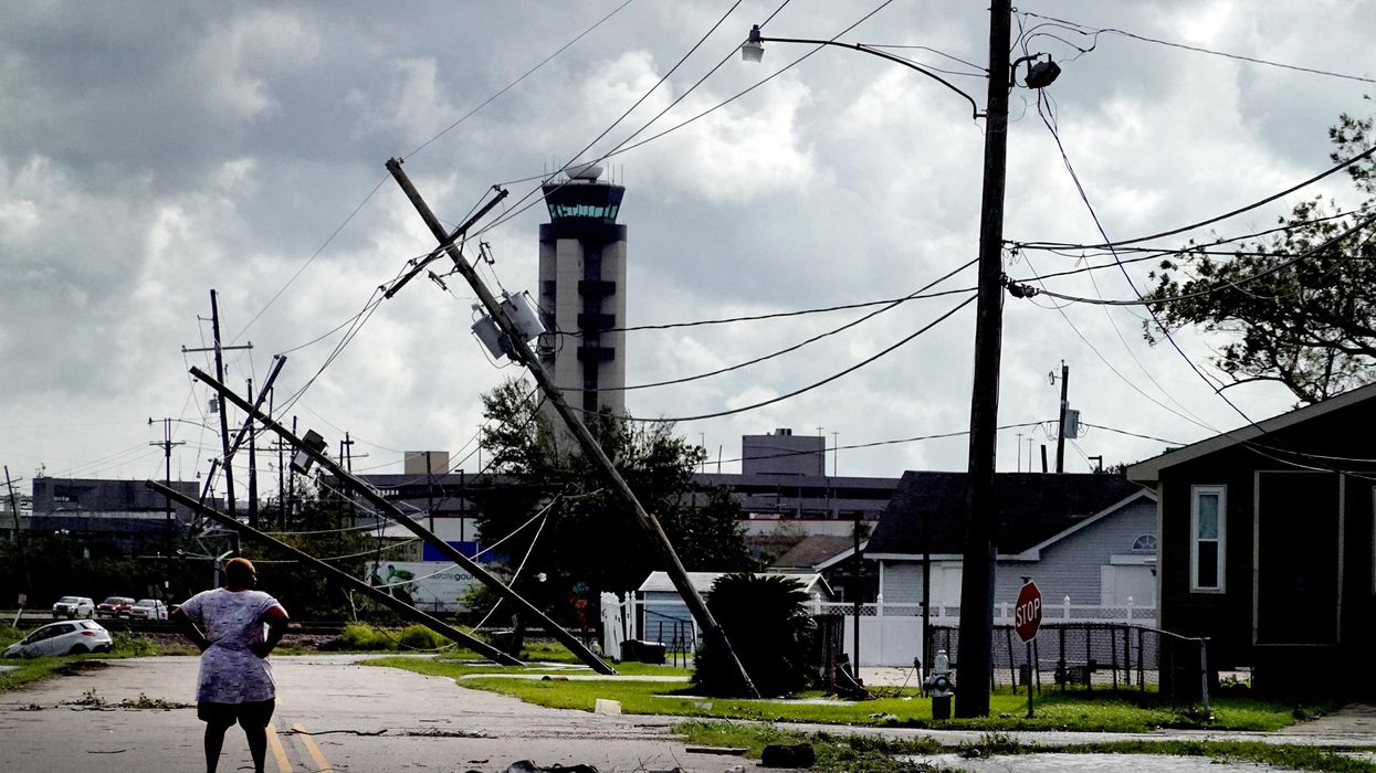 A woman looks over damage to a neighborhood caused by Hurricane Ida on August 30, 2021 in Kenner, Louisiana.