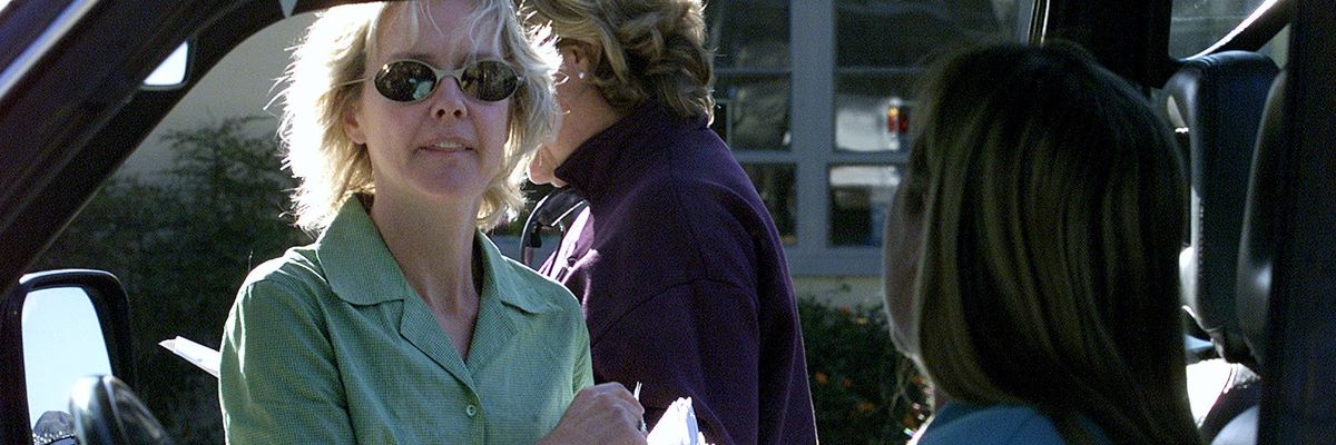 A woman passes out flyers.