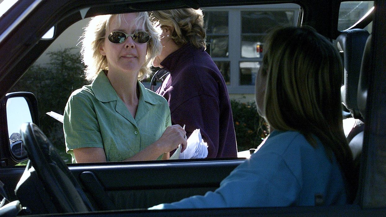 A woman passes out flyers.