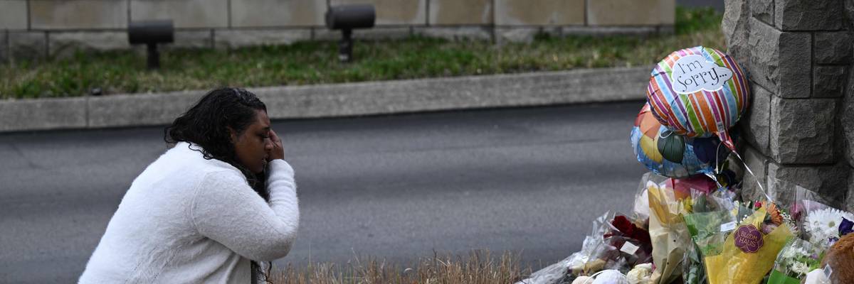 A woman pays her respects at a makeshift memorial for victims outside the Covenant School building at the Covenant Presbyterian Church following a shooting, in Nashville, Tennessee, on March 28, 2023.