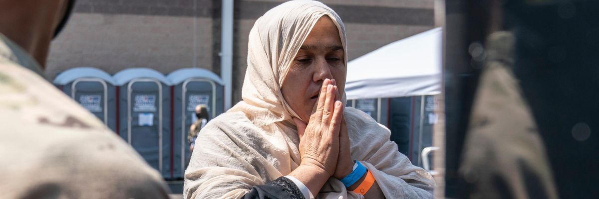 A woman prays as she boards a bus at a processing center for refugees evacuated from Afghanistan at the Dulles Expo Center on August 24, 2021 in Chantilly, Virginia.on August 24, 2021 in Chantilly, Virginia. According to the U.S. State Department, between Sunday morning and Monday morning, 10,400 people were evacuated from Kabul on military flights and approximately 5,900 more people were evacuated on 61 coalition aircraft.(Photo by Joshua Roberts/Getty Images)
