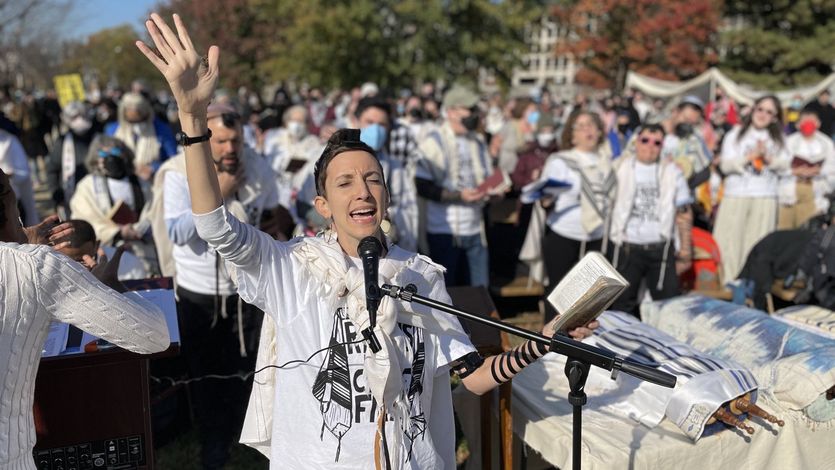 A woman prays into a microphone.