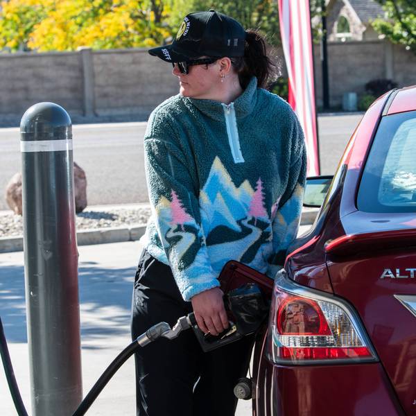 A woman refuels a vehicle at a gas station