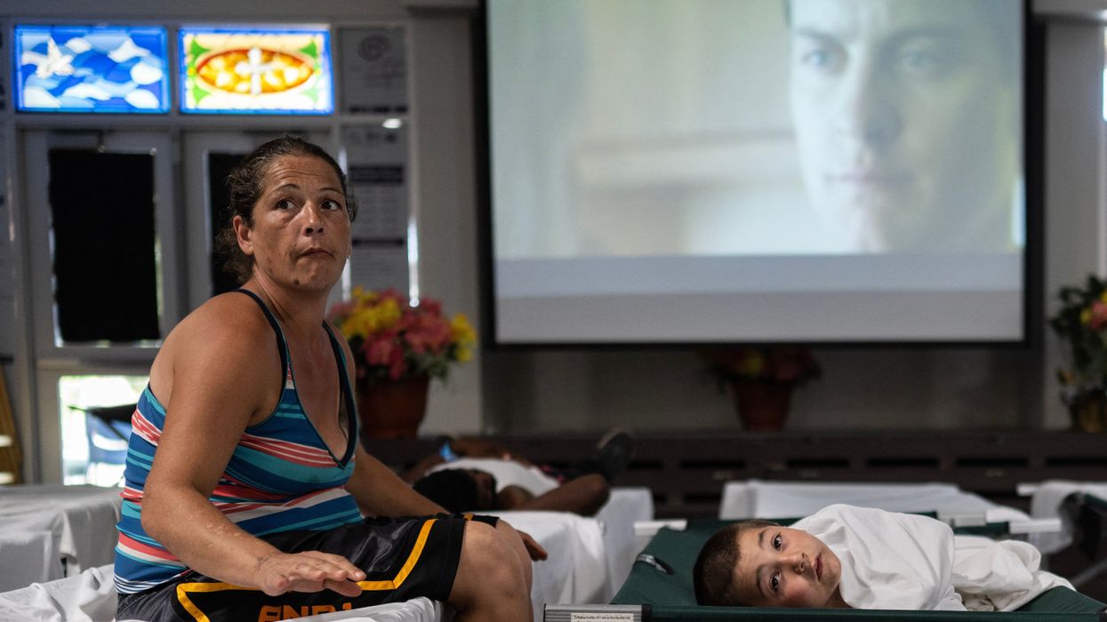A woman rests on a cot at a Salvation Army