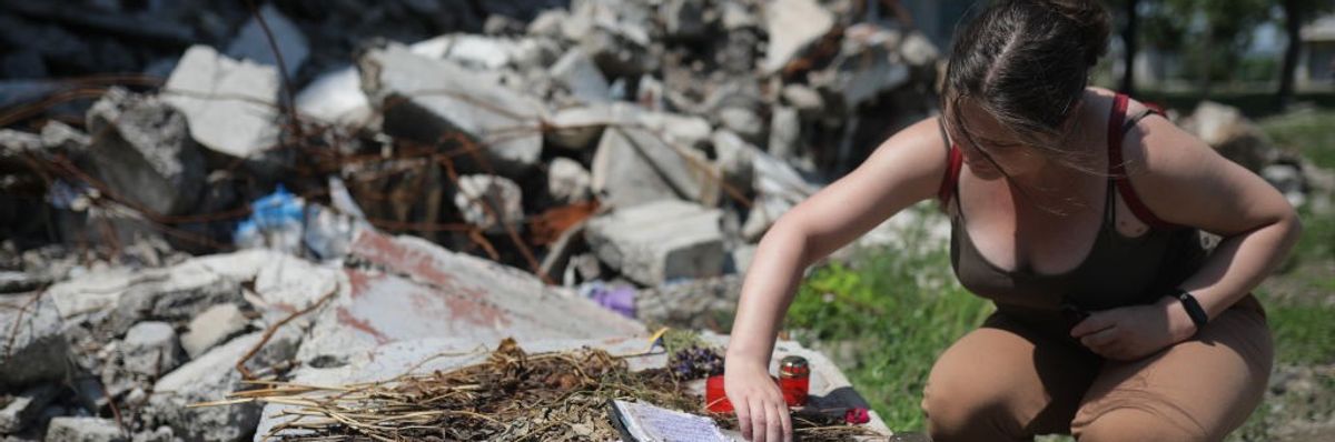 A woman searches through rubble in Ukraine.