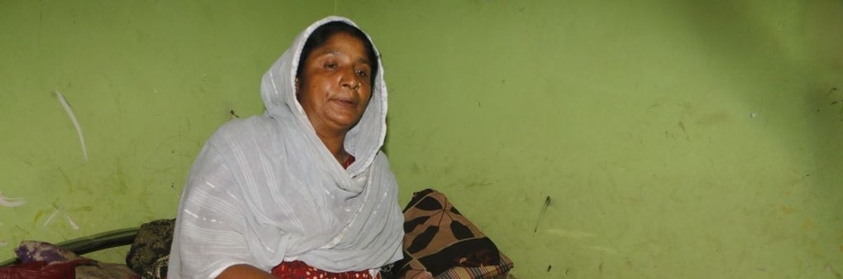 A woman sits with an injured leg.