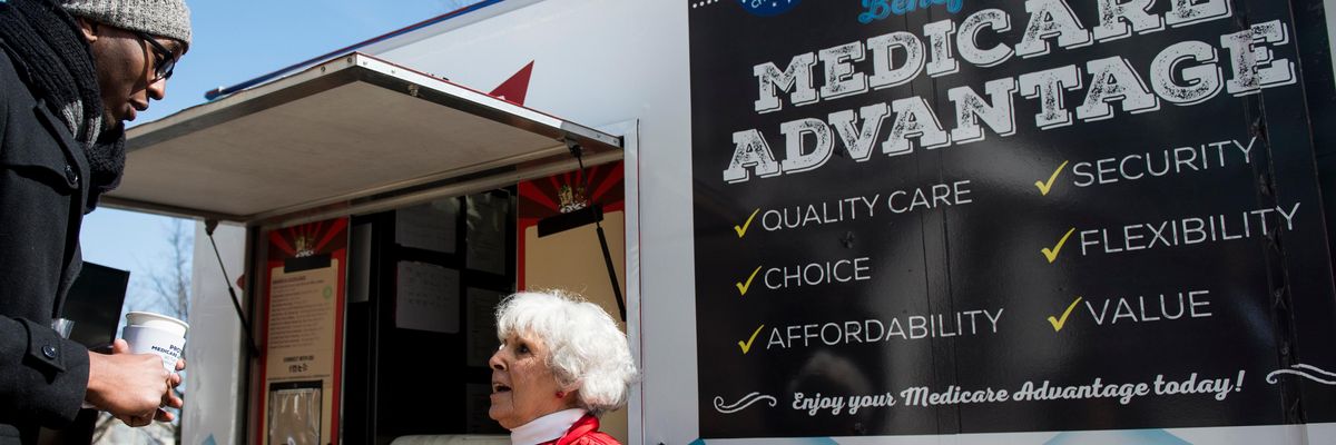 A woman speaks with pedestrians about the supposed benefits of Medicare Advantage