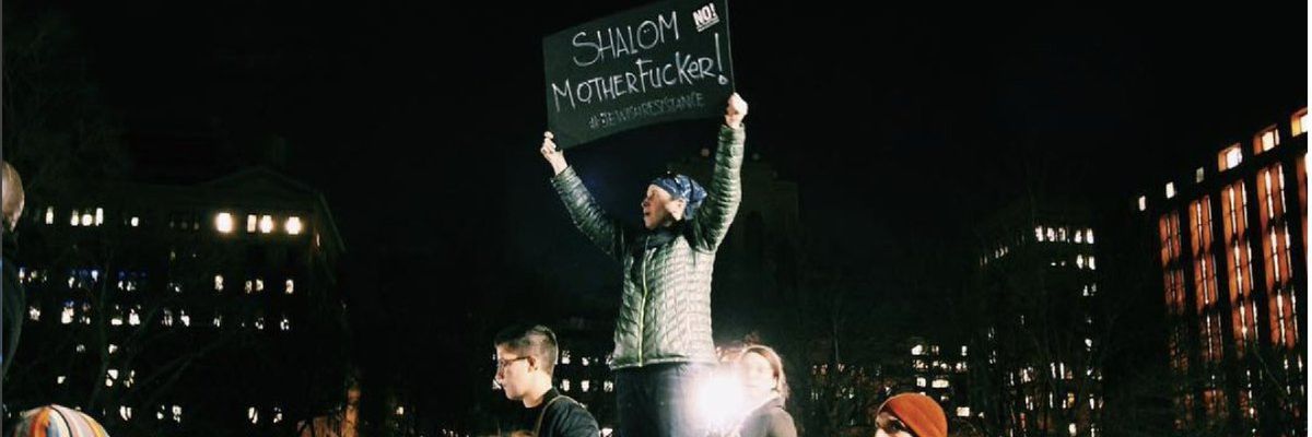 A woman stands in a crowd protesting hate speech and crimes.