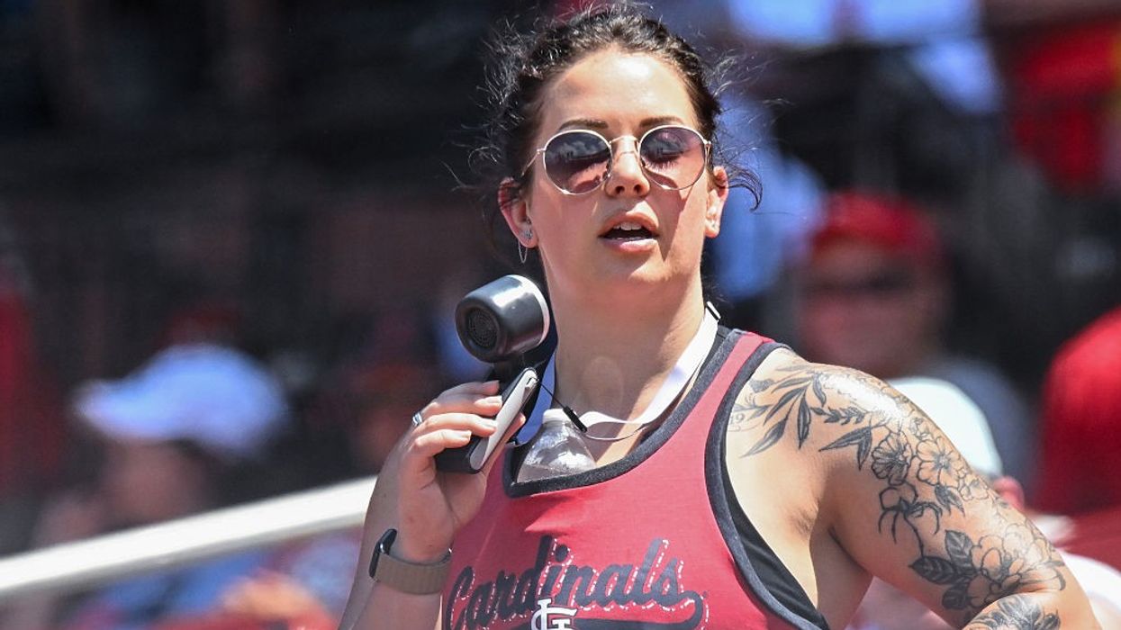 A woman uses a small battery-powered fan to try to stay cool