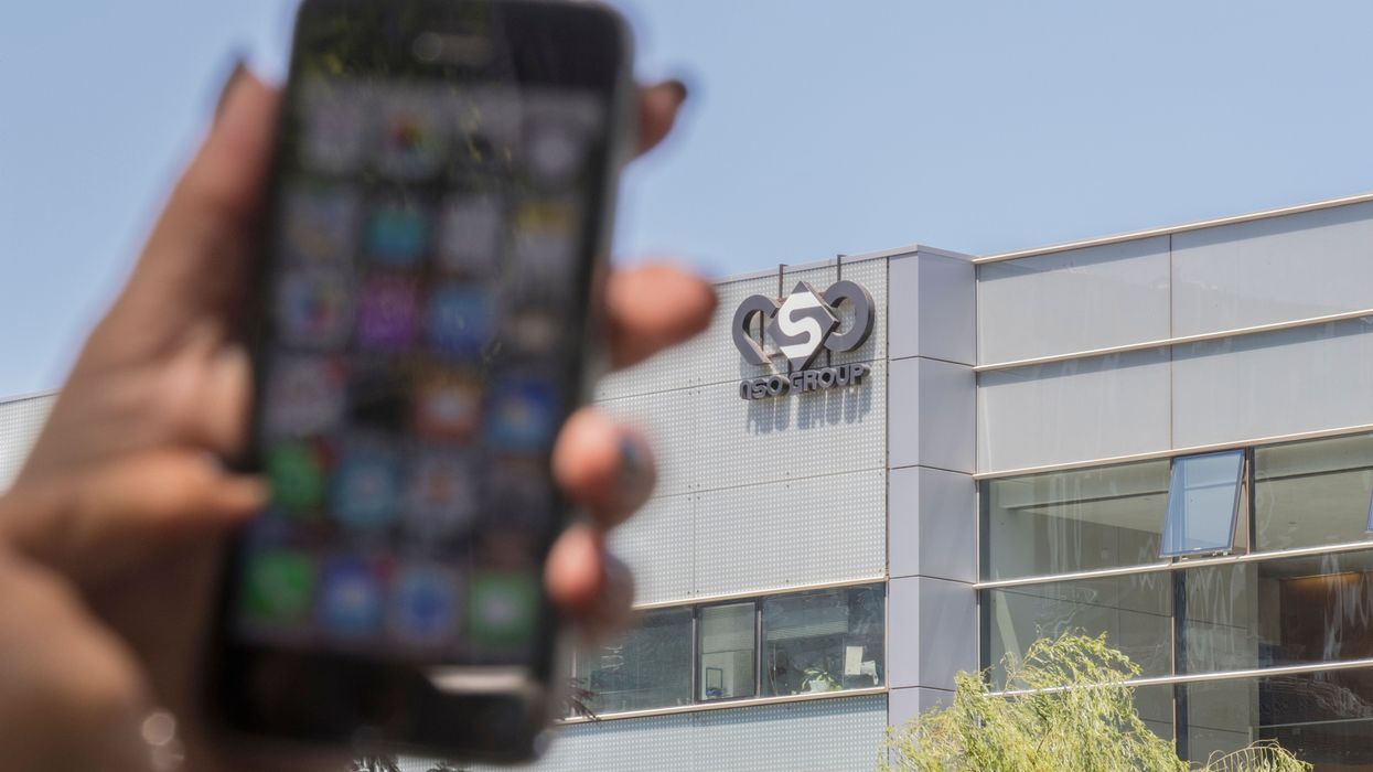 A woman uses an iPhone in front of the building of the NSO Group, developer of the spyware Pegasus, on August 28, 2016, in Herzliya, Israel.