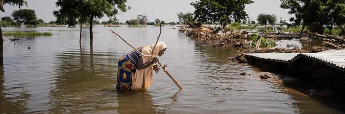A woman wades through floodwater in Nigeria