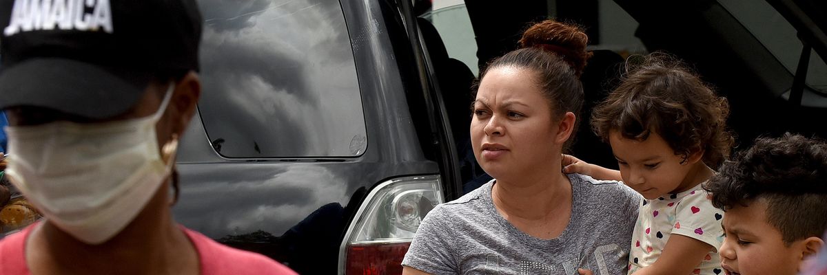 A woman waits at a food bank with her children
