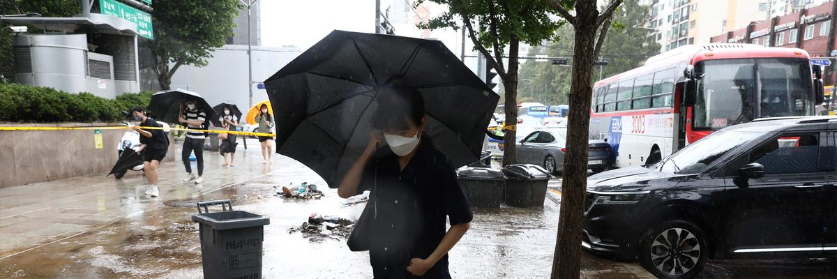 A woman walks in the draining streets of Seoul, South Korea