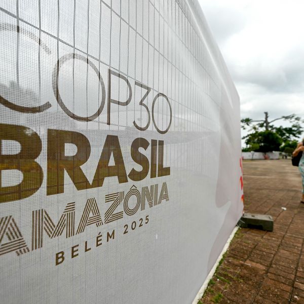 A woman walks past a banner with the United Nations Climate Change Conference logo
