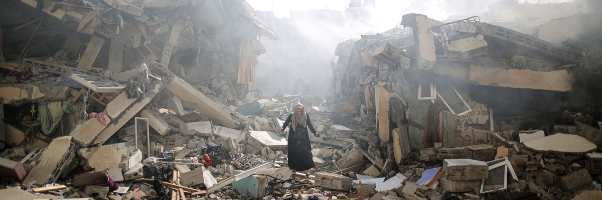 A woman walks through the ruins of Gaza