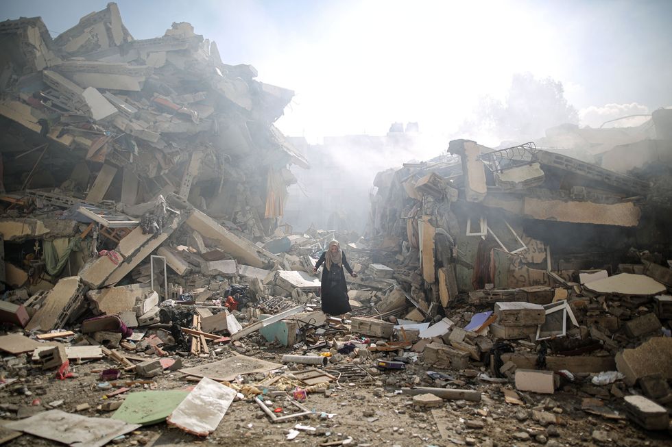 A woman walks through the ruins of Gaza