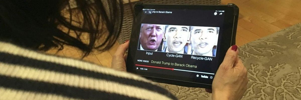 A woman watches a deepfake of Trump and Obama