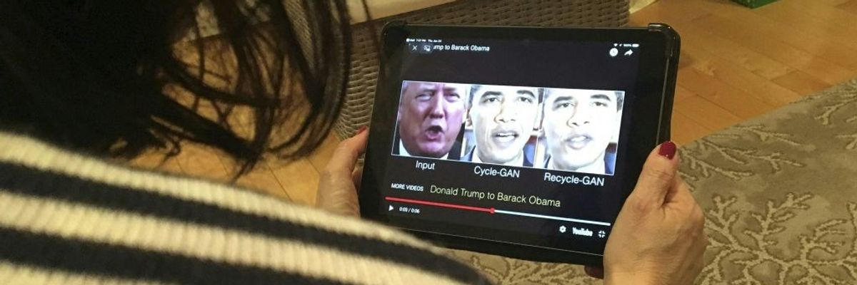 A woman watches a deepfake of Trump and Obama